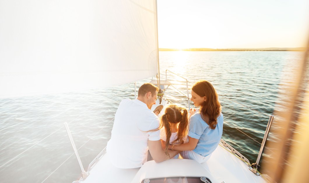 Symbolisches Bild mit Personengruppe im Boot siteznd auf Wasser.