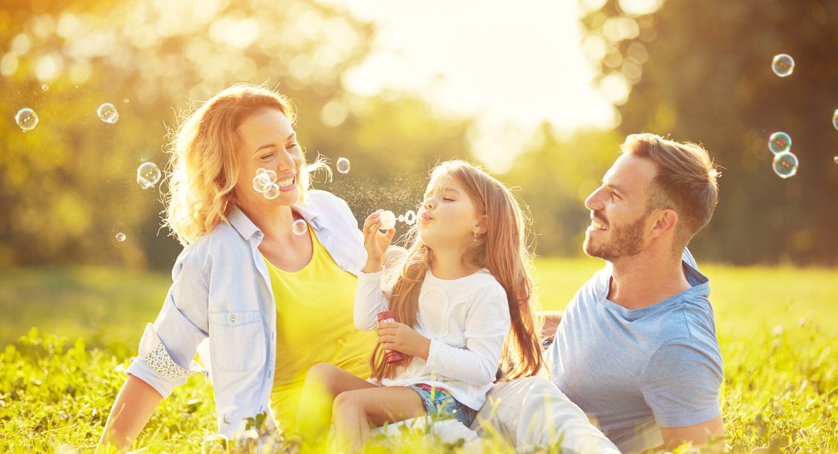 Symbolisches Bild mit Familie im Grünen.